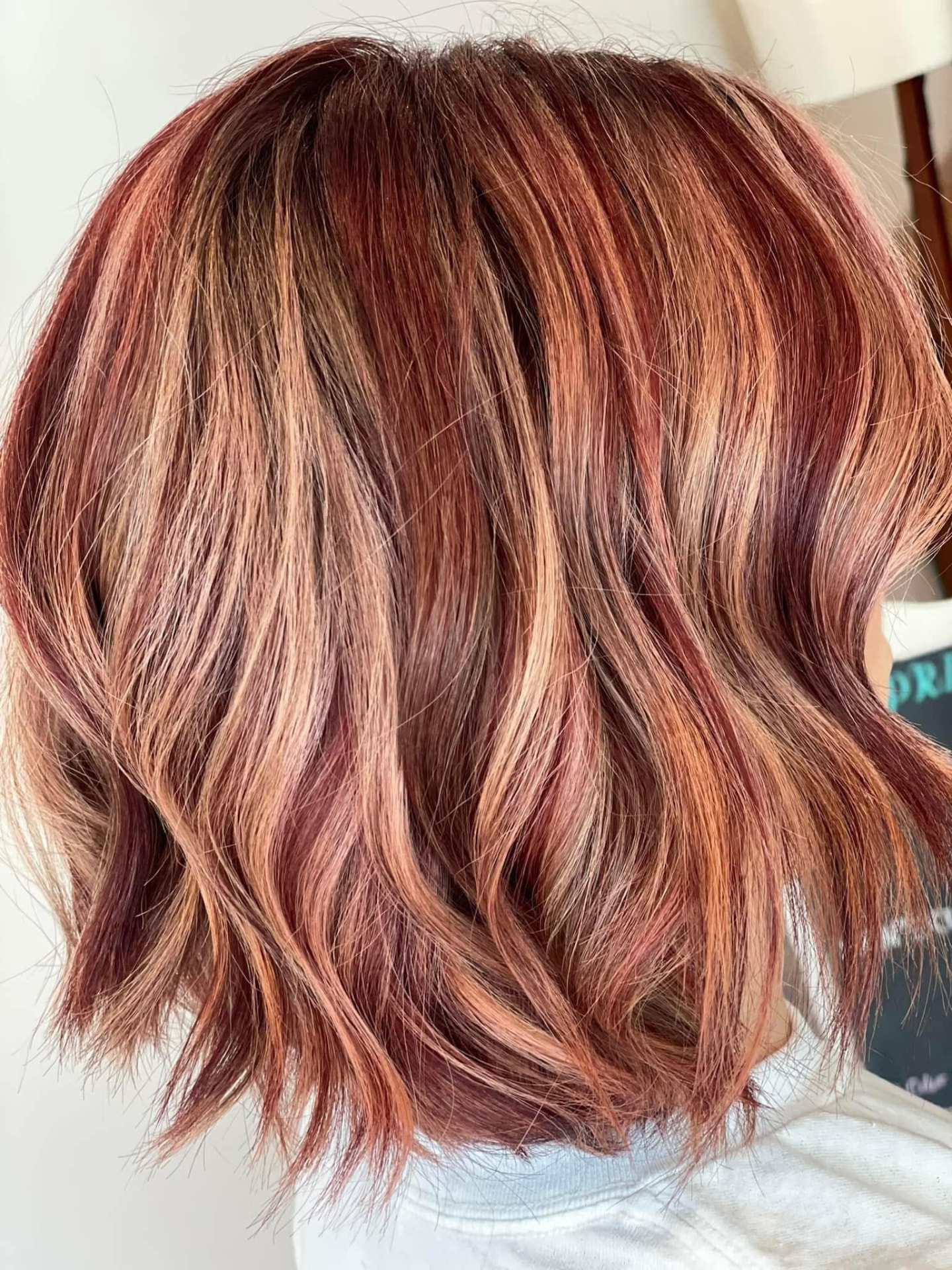 Wavy reddish-brown hair with highlights by Studio 4 Salon in Pass Christian